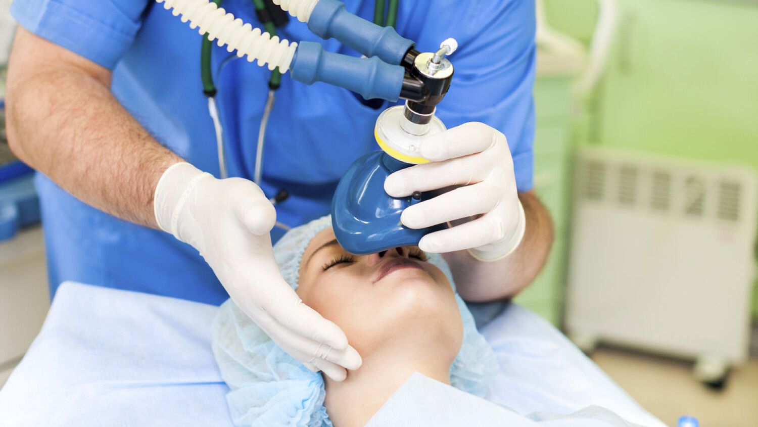 Person som holder maske over pasient